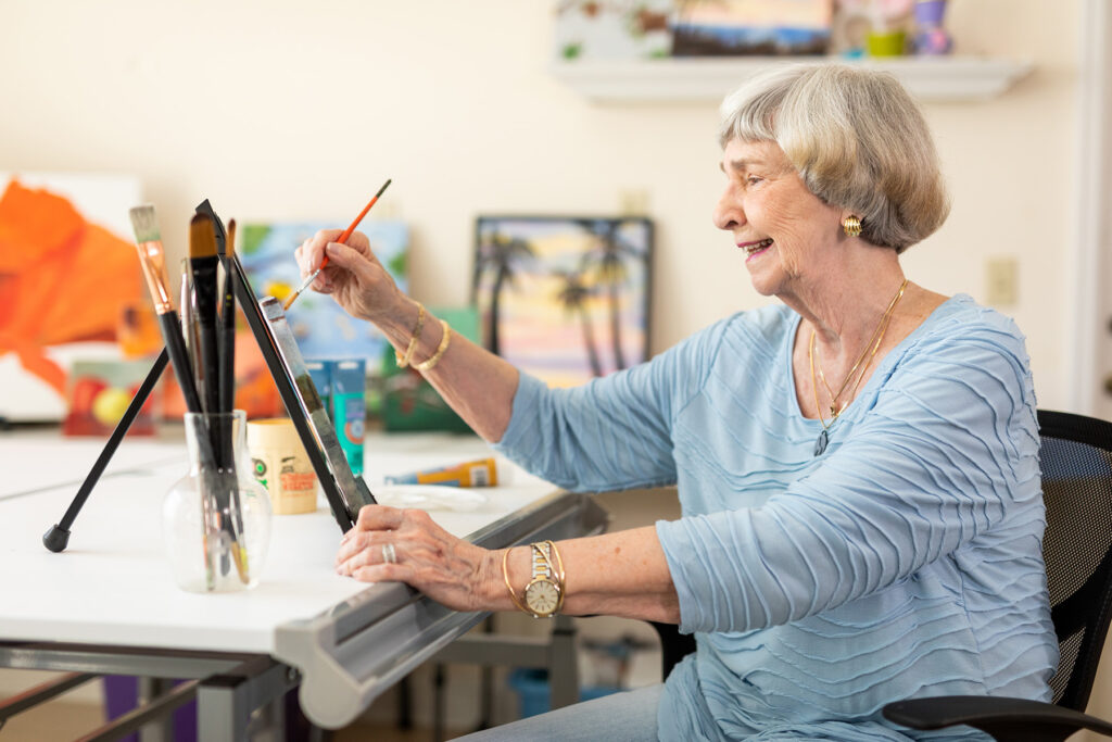 senior resident taking time to enjoy painting a picture