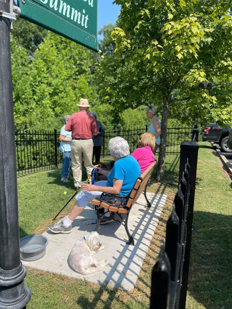 Senior residents sitting at bench at the dog park