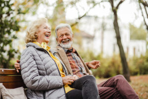 A happy senior couple sitting on a bench together