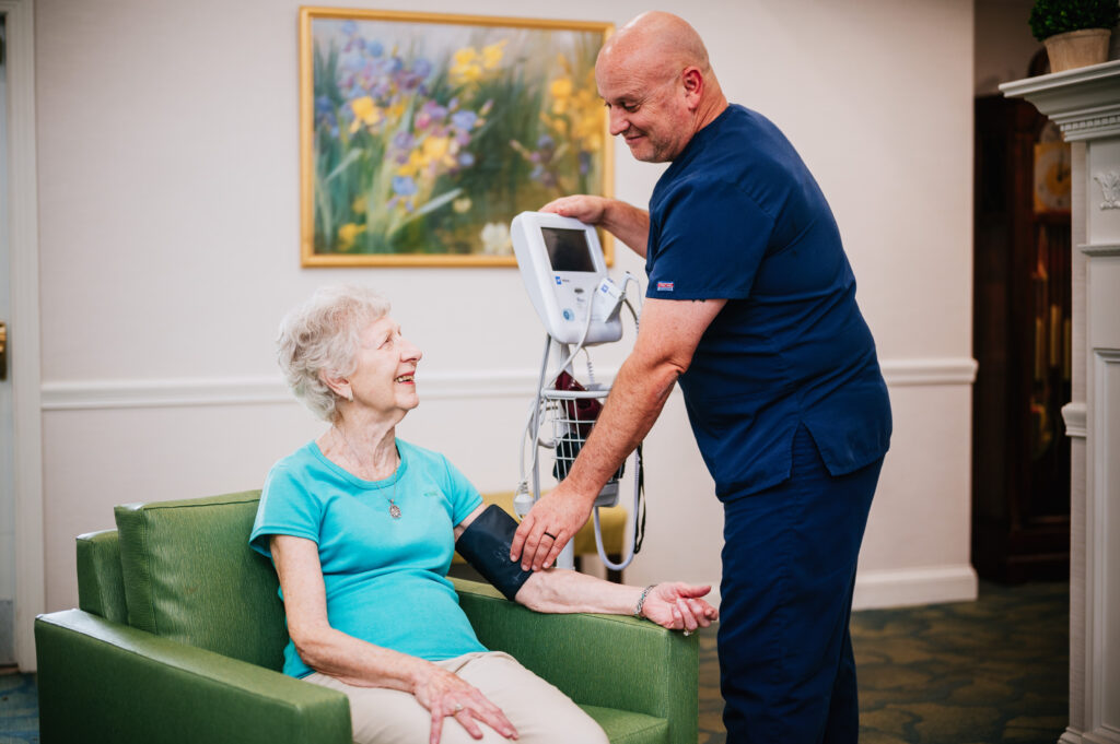 Staff member taking a resident's blood pressure