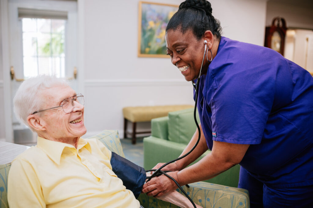 Caretaker taking resident's blood pressure