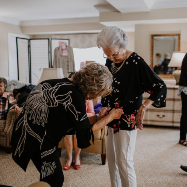 Resident helping a model with finishing touches for the fashion show