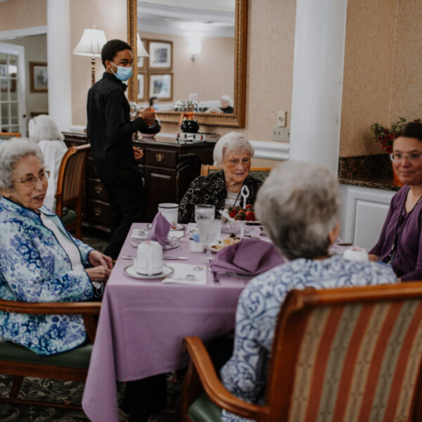 Residents interacting with each other as staff members serve tea and coffee