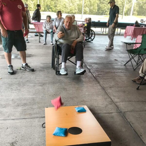 Resident playing corn-hole at picnic