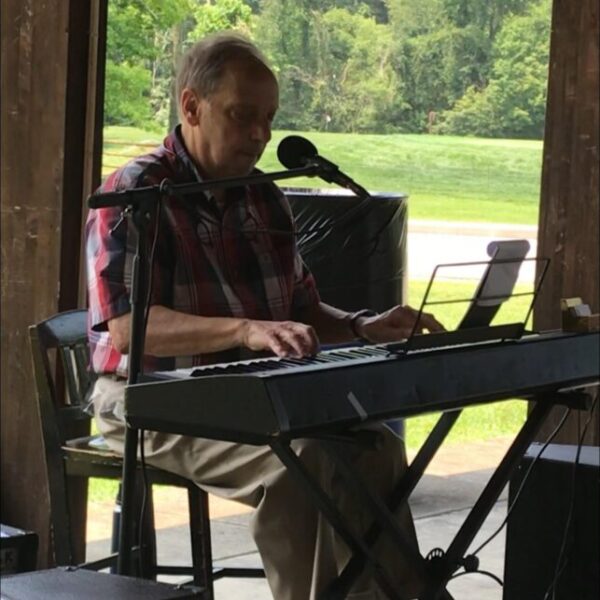 Resident performing by singing and playing the keyboard at the picnic