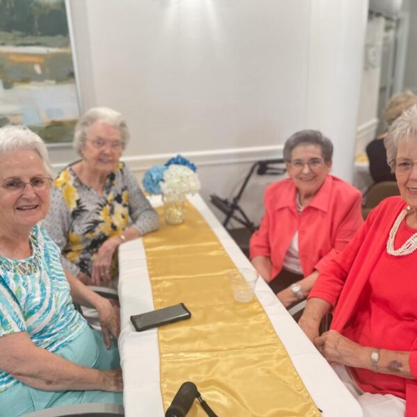 Residents posing at the table for the anniversary celebration