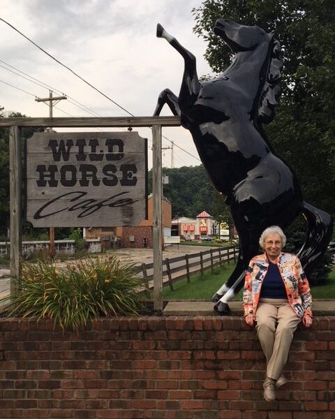 Resident posing in front of Wild Horse cafe sign