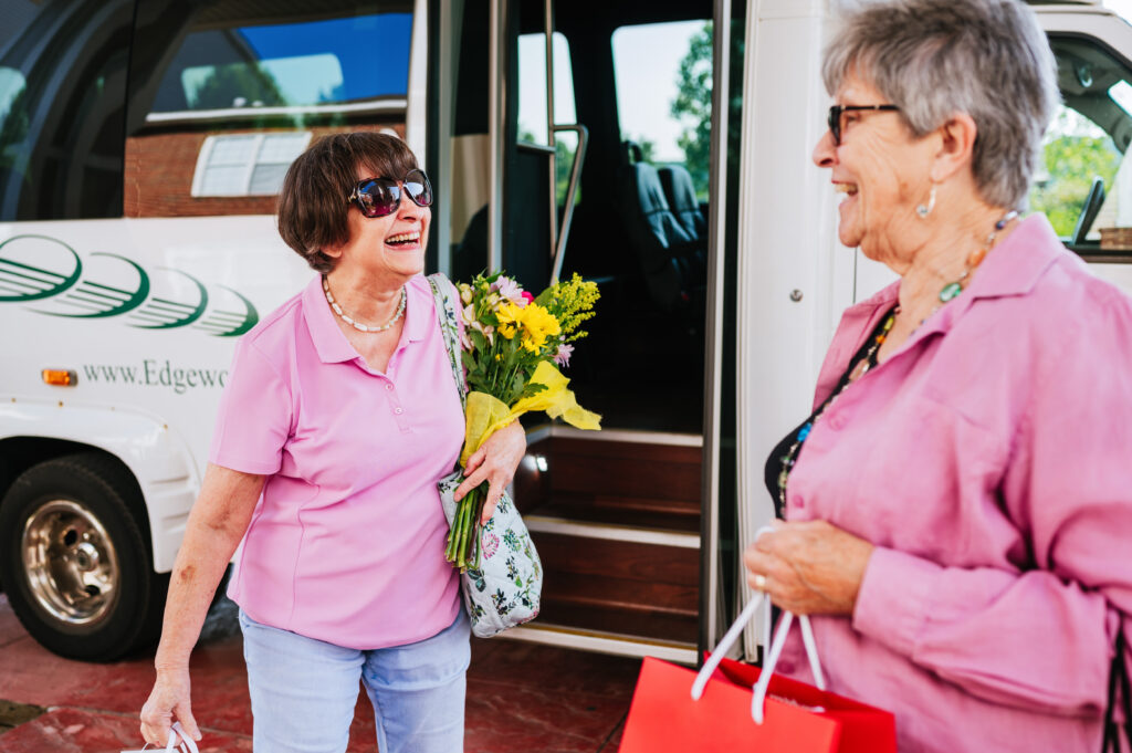 Residents holding flowers in front of Edgewood Summit shuttle