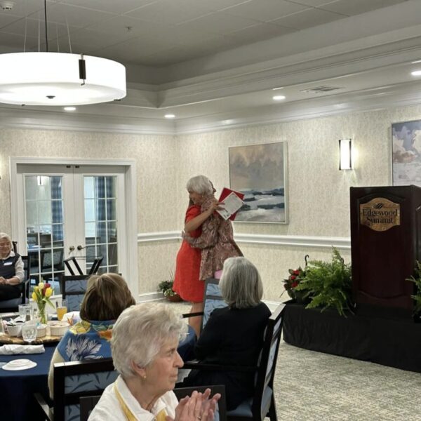 Author Joy Calleway hugging the MC at the Mother's Day luncheon