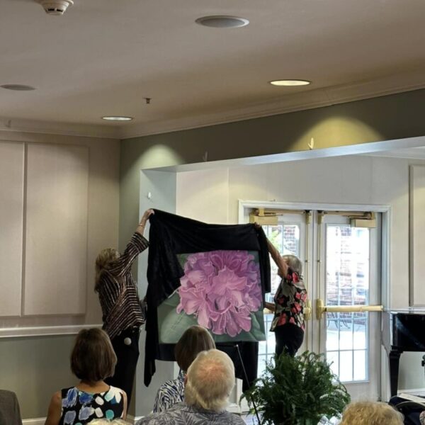 Staff unveiling the flower painting at the Newt and Nancy Thomas gallery