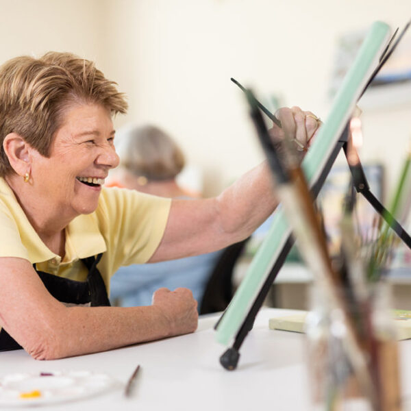 Resident happily completing a painting at the art studio