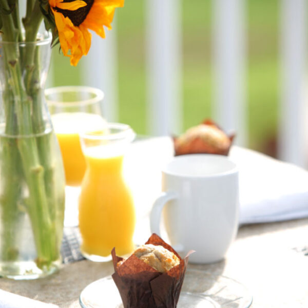 Muffin and orange juice served a table with a sunflower centerpiece