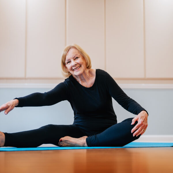 A senior stretching and preparing herself for a group exercising class