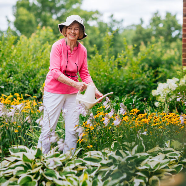 A residents watering the flowers in the community