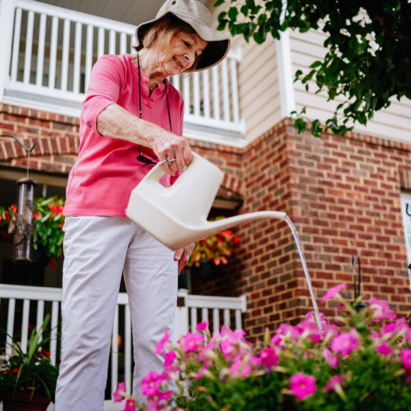 Senior resident watering flowers in the community