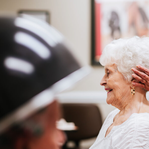 A senior woman getting her fixed by another resident at the community salon