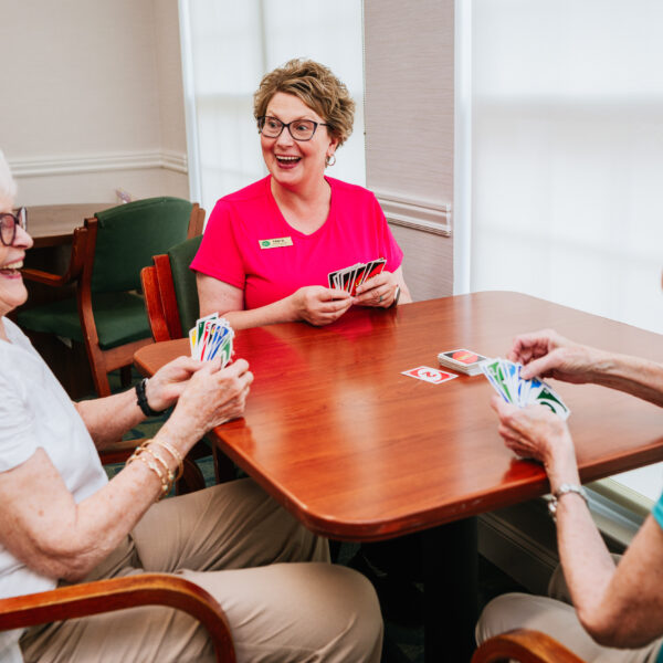 Three female residents playing uno together at the common area