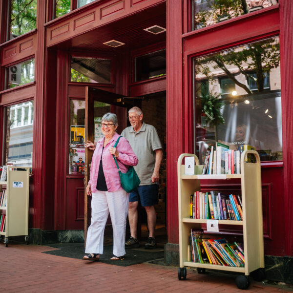 Two seniors exiting a bookstore in the town