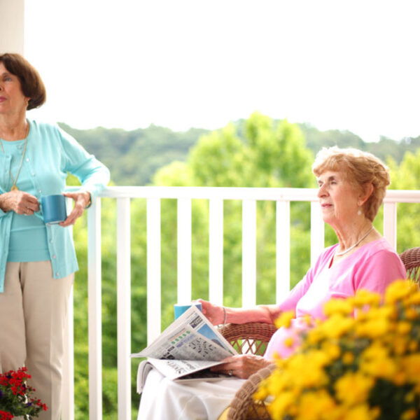 Two residents enjoying their morning and overseeing something from their balcony