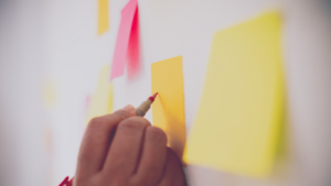 Woman writing something down on a post-it on the wall