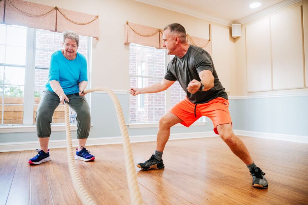 A personal trainer helping a senior woman with her workout