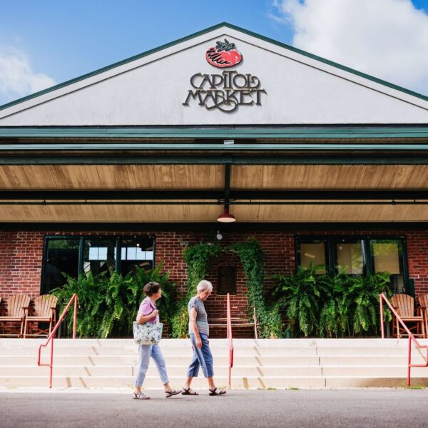 Two senior women walking in front of Capitol Market, a grocery store in town