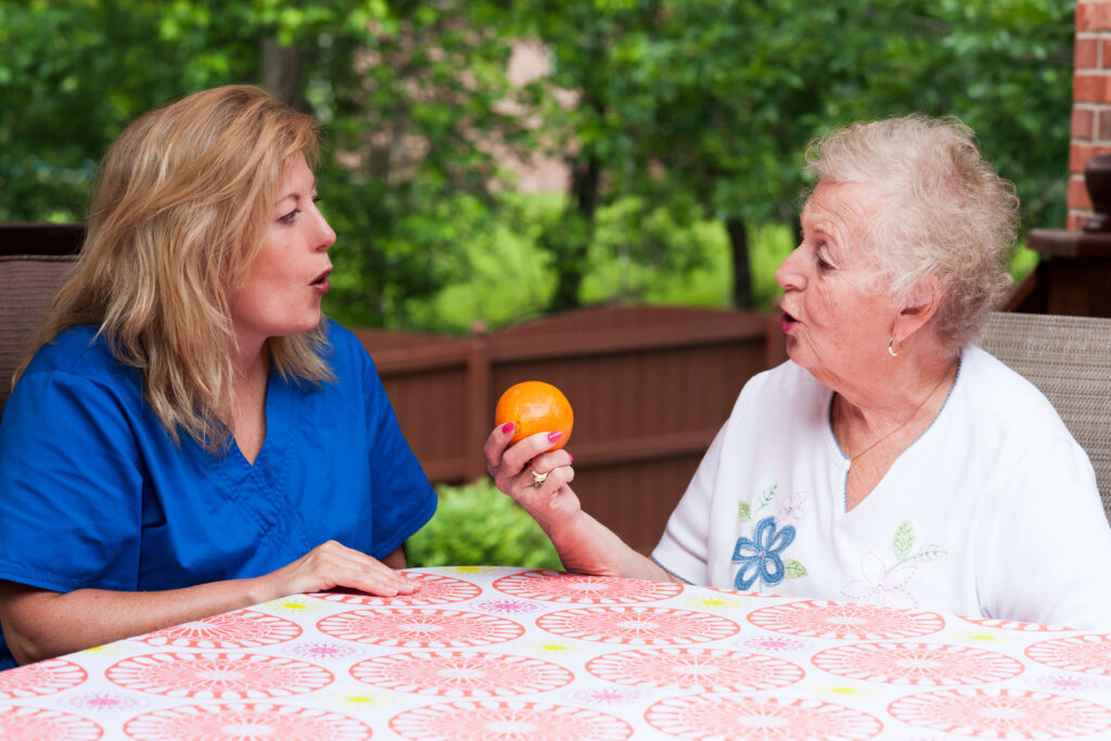 Speech therapist helping a female stroke patient sounding words together